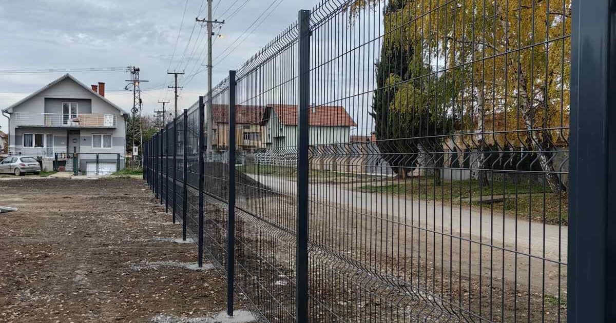 3D panelna ograda u antracit boji sa sveže betoniranim stubovima, postavljena uz ulicu